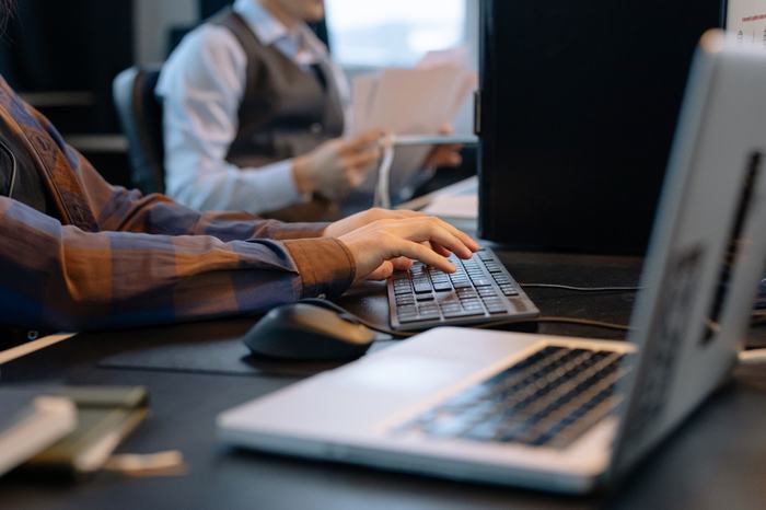 Administrative staff member working on a laptop in an office